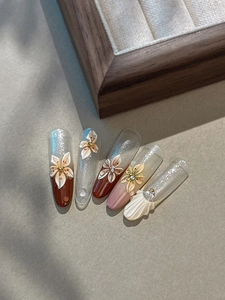 Détail de fleurs 3D gaufrées avec strass et coquillages sur des ongles décorés