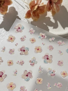 Macro detail of 3D embossed floral nail art stickers with elegant pastel jelly colors