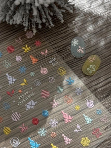 Macro detail of 5D embossed Christmas nail stickers with colorful trees and snowflakes