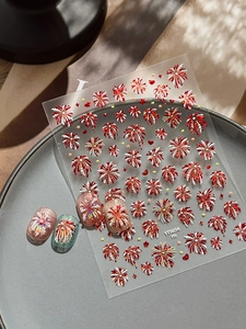Macro shot of 3D red firework nail art stickers with embossed stars and heart patterns