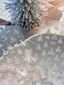 Vue détaillée des autocollants d'ongles 3D avec sapins de Noël et nœuds en relief