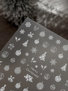 Macro detail of 3D embossed Christmas nail stickers with snowflakes and reindeer motifs