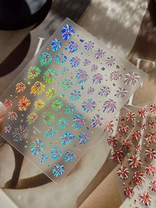 Detailed macro view of 3D holographic laser and metallic red firework nail art stickers