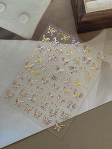 Detail of gold foil butterfly nail stickers with purple gradients on model YT6371