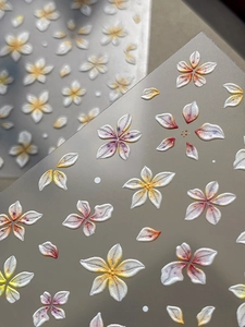 Gros plan d'autocollants 3D de fleurs en relief avec un dégradé nacré pour ongles