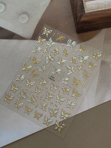 Detailed view of YT6374 gold embossed butterfly nail stickers with pearlescent texture