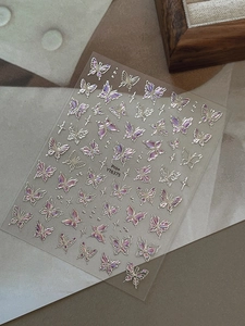 Macro detail of laser iridescent butterfly nail art stickers with starlight patterns