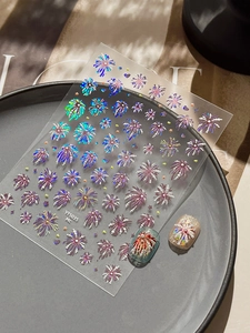 Close-up of holographic firework nail stickers with 3D texture and pearl accents