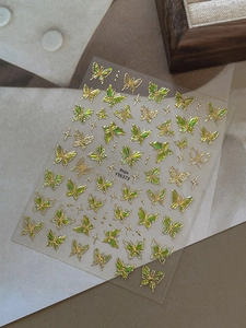 Detailed view of butterfly nail stickers with green gold gradient and metallic finish