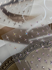Macro detail of holographic star nail stickers with rhinestones and rose gold metallic finish
