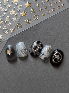 Détail d'autocollants pour ongles étoiles dorées et argentées avec designs de manucure 3D