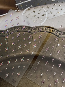 Macro shot of YT6499 nail art stickers with four-pointed stars and shiny rhinestones