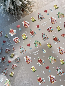 Macro shot of 3D Christmas nail stickers with gingerbread house and snowman motifs