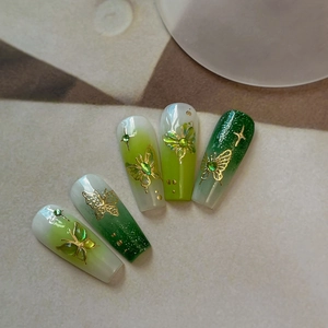 Green gradient coffin nails with golden butterfly relief and cat eye gemstones