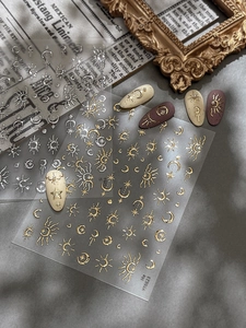 Macro detail of gold and silver sun and moon nail stickers on elegant manicure art