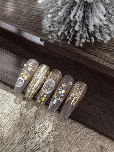 Detail of champagne gold Christmas nail stickers with snowflakes and 3D trees