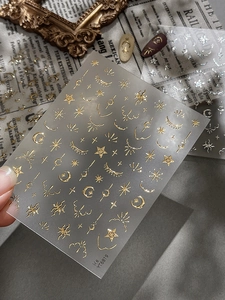 Detail view of gold and silver sun and moon nail stickers with metallic relief texture