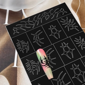 Tribal style nail art stickers with white linear patterns on a long gradient nail tip
