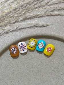 Dettaglio di adesivi per nail art bohémien a rilievo con motivi floreali e geometrici vintage