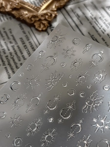 Detail of 3D embossed silver metallic nail stickers with celestial sun moon and stars