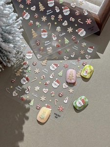 Macro shot of 3D embossed Christmas nail stickers with Santa and gingerbread motifs