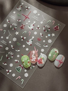 Dettaglio di adesivi nail art natalizi con campanelli e alberi in rilievo su pelle