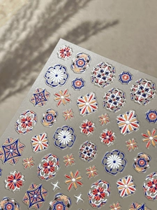 Dettaglio macro di adesivi per unghie 5D in rilievo con motivi floreali mandala boho