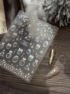 Close-up of holographic silver Christmas nail stickers with snowflakes and trees