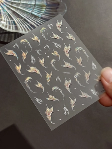 Detail of holographic golden butterfly nail art stickers with relief starlight effects