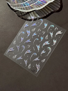 Detail of holographic butterfly nail stickers with iridescent laser finish on dark surface