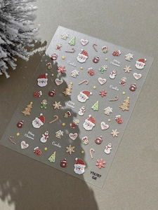 Macro shot of 3D embossed Christmas nail art stickers with Santa and gingerbread motifs
