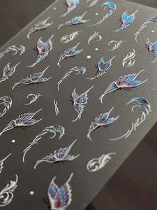 Detailed macro view of embossed holographic butterfly nail art stickers with silver lines