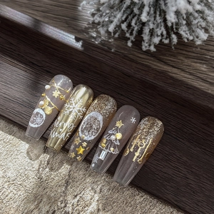 Christmas snowflake nail stickers with gold plating and 3D star designs on wood background