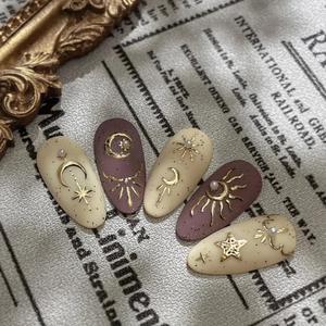 Vintage sun and moon nail charms with gold embossed star patterns on matte base nails