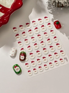 Stickers nail art Père Noël 3D en relief sur planche et appliqués sur ongles manucurés