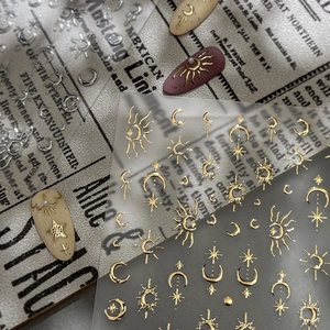 Golden and silver celestial nail art stickers featuring sun, moon, and star patterns