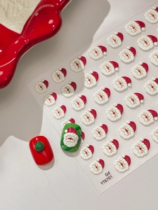 Détail de stickers 3D Père Noël pour ongles sur manucure festive rouge et verte