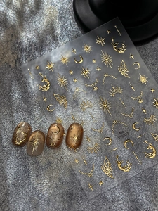 Detailed view of gold embossed celestial nail stickers with moon star and cloud designs