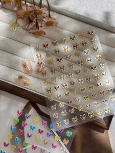 Détails d'autocollants 3D pour ongles papillon avec bordure dorée et textures émail