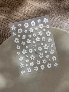 Vue détaillée de stickers pour ongles gaufrés 5D avec fleurs de frangipanier sur assiette