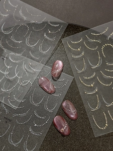 3D nail stickers with gold and silver chain lines applied to luxury cat eye press-on nails