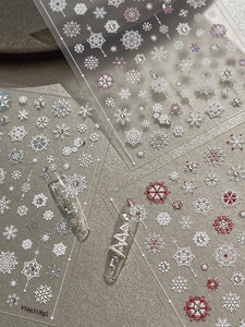 Detail of Christmas nail art stickers with 3D rhinestones and festive snowflake patterns