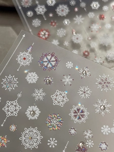 Macro detail of snowflake nail stickers with holographic laser finish and rhinestones