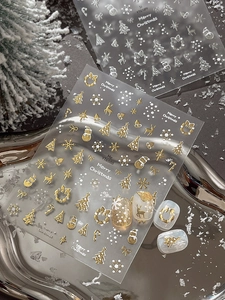 Detailed view of gold and silver Christmas nail art stickers with reindeer and tree motifs