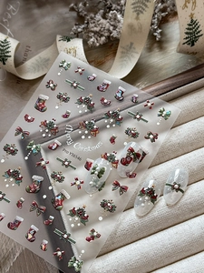 Macro detail of 5D embossed Christmas nail stickers with festive holly and bow patterns