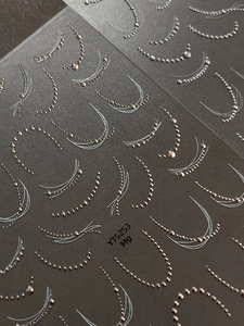 Macro shot of 3D metallic gold and silver nail chain stickers for French manicure art