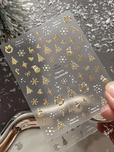 Detailed view of Christmas nail stickers with gold reindeer, snowflakes and trees