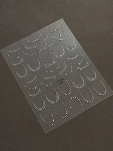 Close-up of silver metallic chain nail art stickers with elegant line patterns