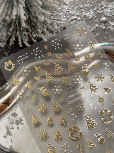 Detail of gold and white Christmas nail stickers with reindeer and snowflake motifs