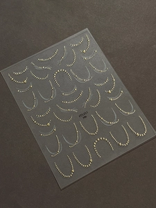 Macro detail of gold metallic chain and bead nail art stickers in model YT5251
